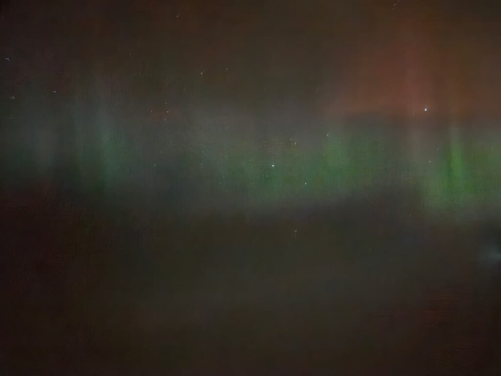 Pale northern lights seen from a plane to Iceland