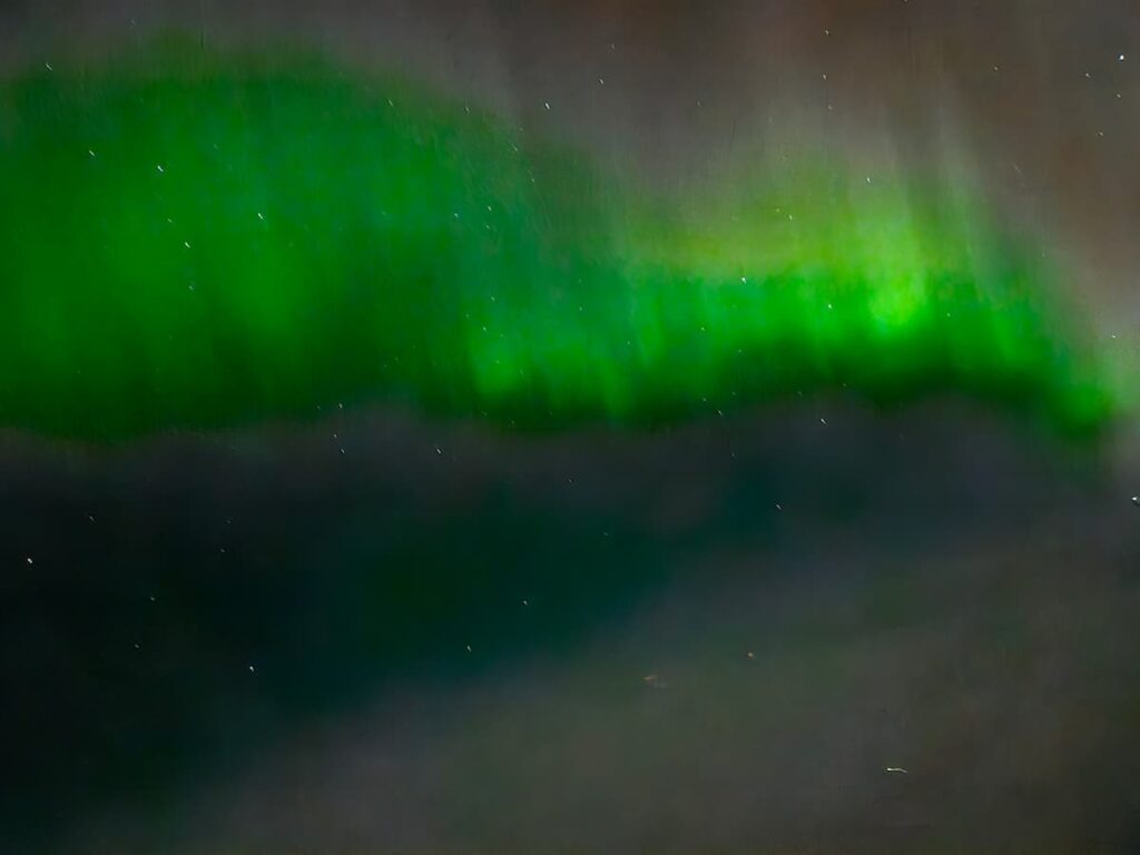 The northern lights in vivid green, photo taken from a plane to Iceland